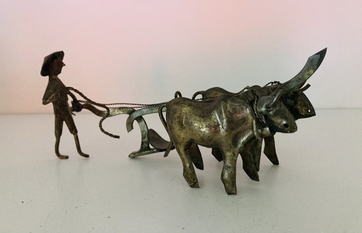 Statue d'un fermier asiatique avec des bœufs labourant sa terre