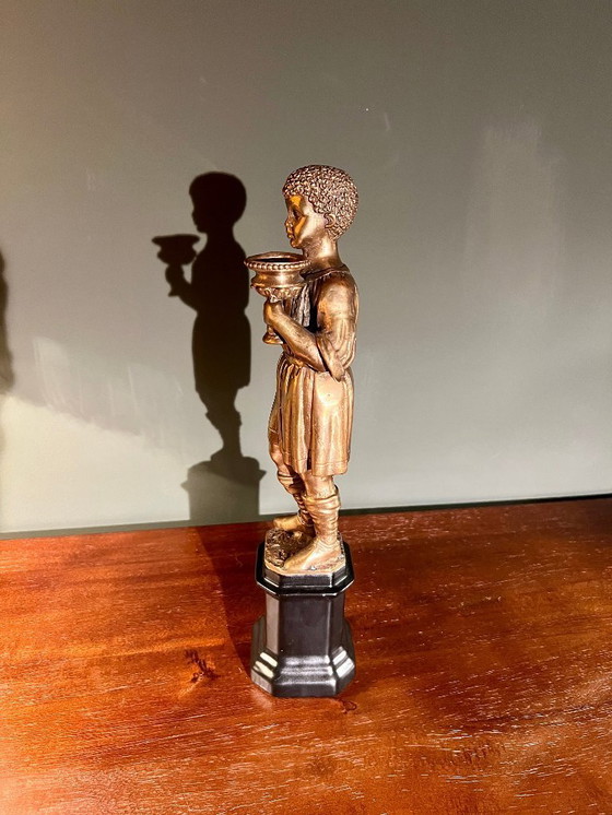 Image 1 of Rarität! Kerzenständer mit der Abbildung eines orientalischen Jünglings aus Messing auf schwarzem Porzellanfuß, 20. Jahrhundert 