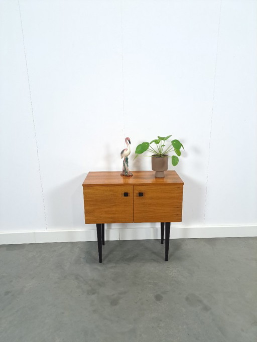 Small cabinet with black high legs and 2 doors