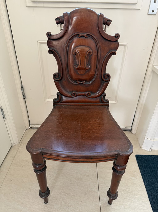 Chaise ancienne en acajou ornée de riches sculptures sur bois