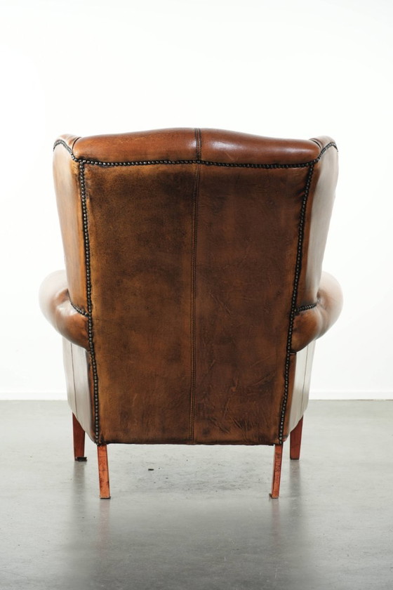 Image 1 of Comfortabele oorfauteuil gemaakt van schapenleer afgewerkt met siernagels en een karaktervolle uitstraling in Engelse stijl