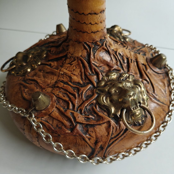 Image 1 of Carafe vintage recouverte de cuir, ornée de têtes de lion et d'une chaînette