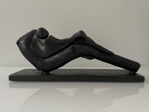 Expressive wooden sculpture with a reclining figure