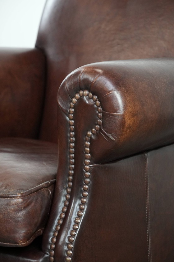 Image 1 of Fauteuil en peau de mouton aux couleurs chaudes et à la finition classique orné de clous décoratifs