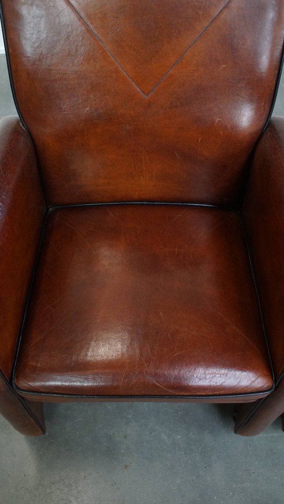 Image 1 of 2 x Vintage schapenleren eetkamerstoel met zwarte biezen op wieltjes