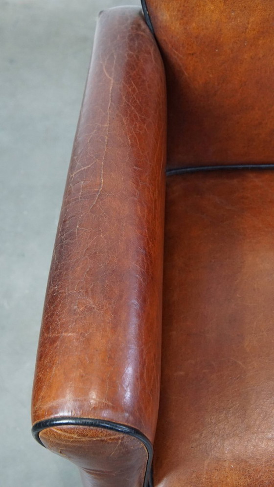 Image 1 of 6 x Vintage sheepskin dining chair with black piping on wheels