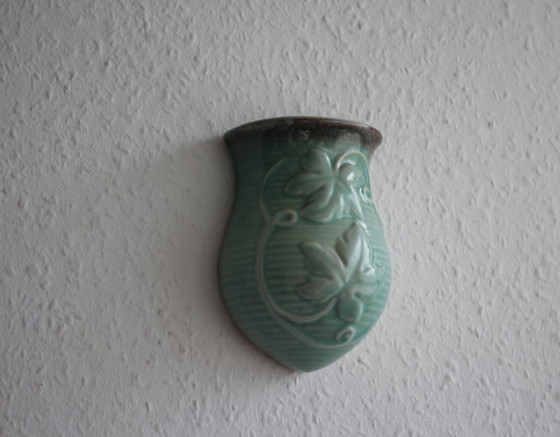 Image 1 of Lichtgroene vintage keramische wandvaas met wijnrankdecoratie.