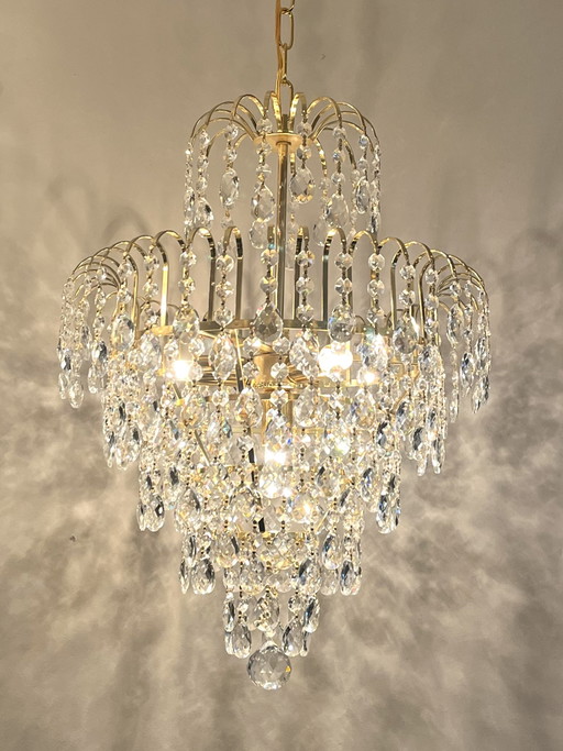 Lampadario di cristallo con struttura dorata a goccia sfaccettata
