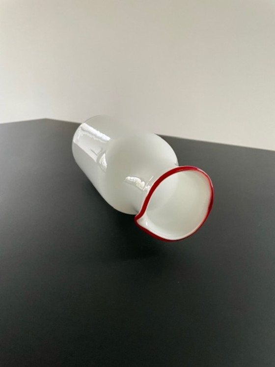 Image 1 of Caraffa dal design scandinavo in vetro bianco con bordo rosso.