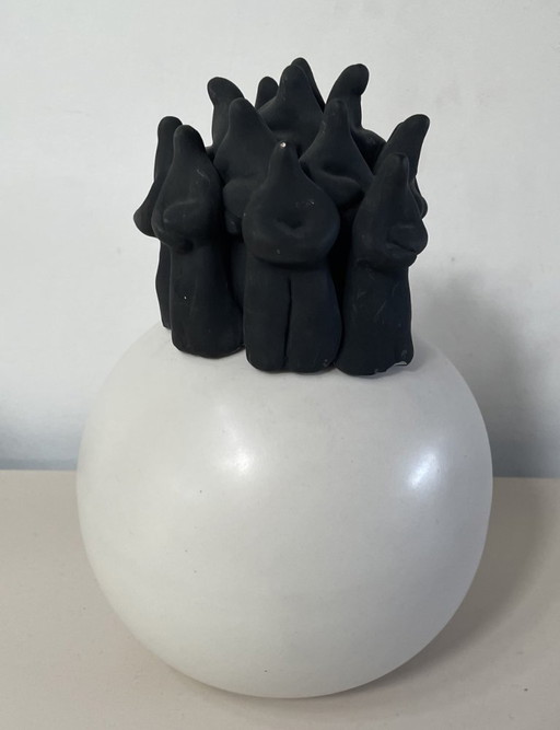 Bildhauerei mit schwarzen Figuren auf weißer Kugel