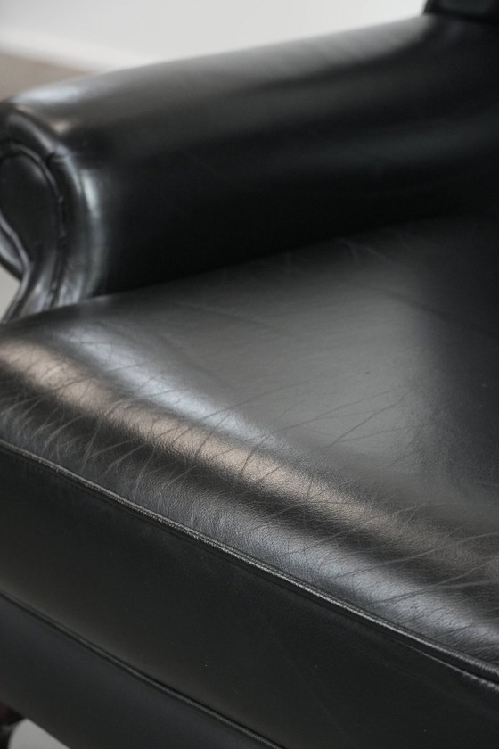 Image 1 of Smooth black cowhide Chesterfield wingback armchair in English style with color-matched piping