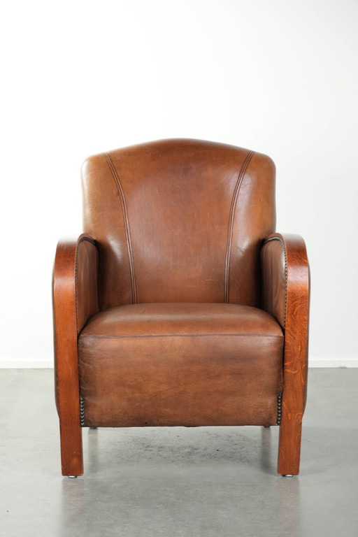 Beautiful sheepskin armchair in Art Deco style with wooden armrests