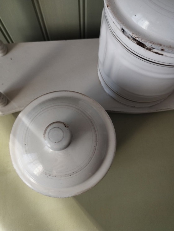 Image 1 of Antieke dozen gemaakt van wit geëmailleerd plaatmetaal met gegroefde randen en gouden versiering.