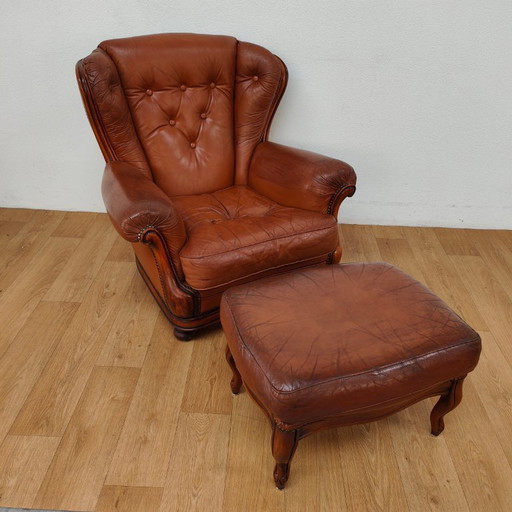 Vintage cognac kleurige lederen fauteuil, oorfauteuil. Stoel met hocker leer.