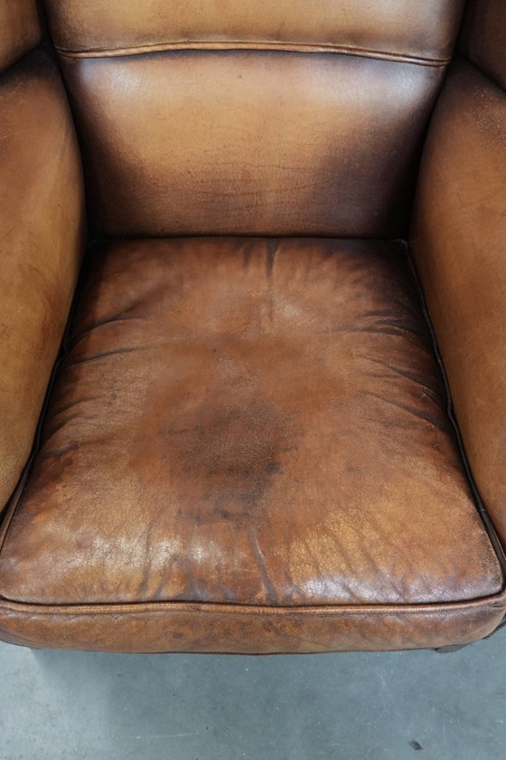 Image 1 of Sillón orejero de piel de oveja acabado con clavos decorativos