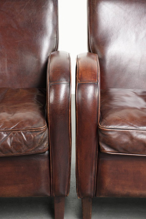 Image 1 of 2x dunkel cognacfarbene Schaffellsessel mit abgerundeten Formen und elegantem Design
