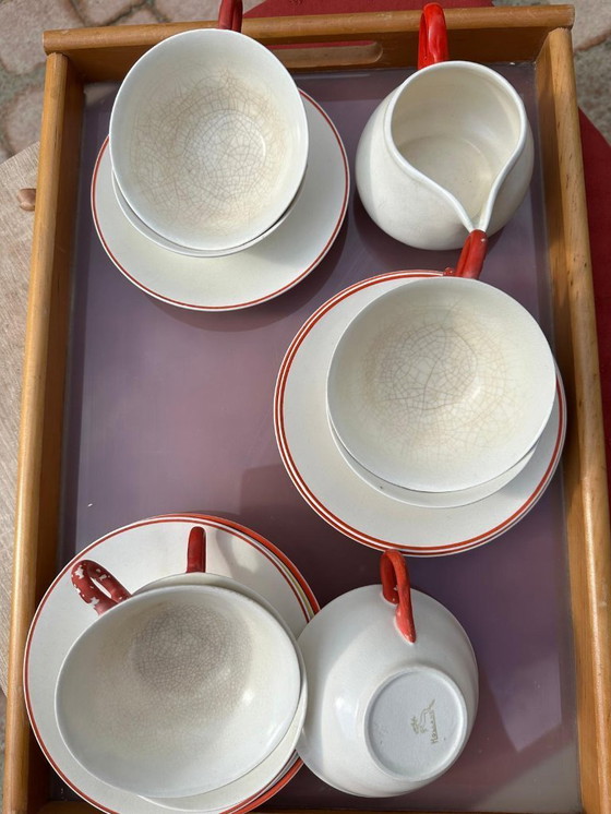 Image 1 of Set van 7 aardewerken kopjes, 5 schotels en 1 melkkan. Gemerkt met afbeelding van een springend hert en het woord 'Holland'.    