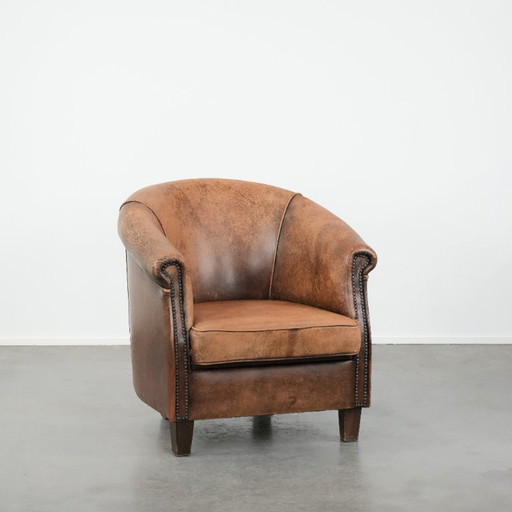 Timeless vintage sheepskin club armchair with character and a beautiful patina