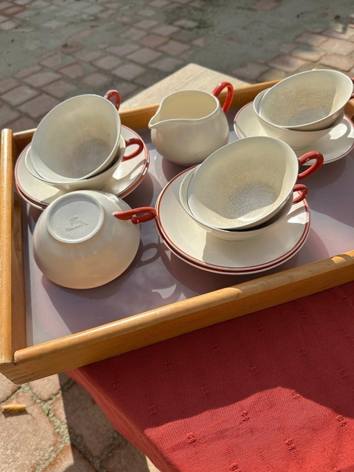 Set van 7 aardewerken kopjes, 5 schotels en 1 melkkan. Gemerkt met afbeelding van een springend hert en het woord 'Holland'.    