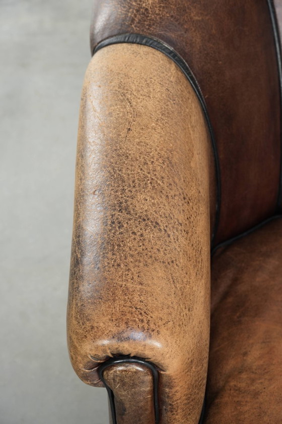 Image 1 of Leuke vintage schapenleren clubfauteuil in Engelse stijl met zwarte biezen