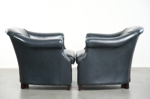 2 comode poltrone club in pelle bovina blu scuro dal design unico e senza tempo.