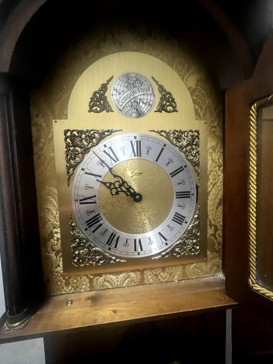 Image 1 of Eine hölzerne Pendeluhr mit einem Schweizer mechanischen Uhrwerk