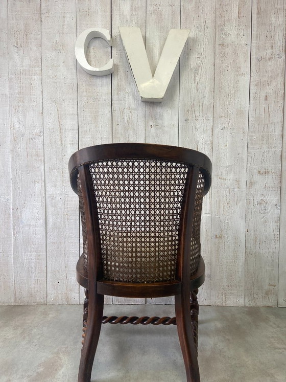 Image 1 of Poltrona antica con intreccio in vimini e decorazioni in legno.
