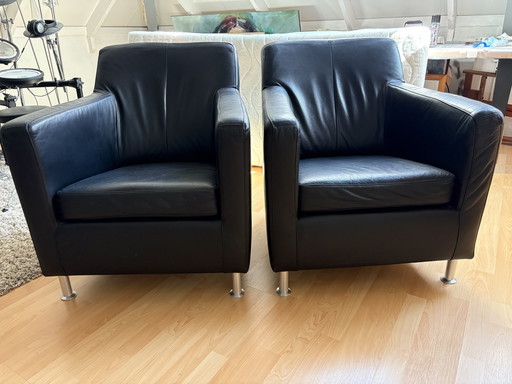 2x black leather armchairs