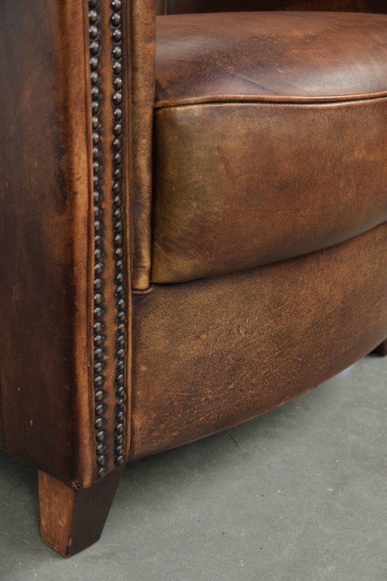 Sturdy and characterful sheepskin club armchair with a beautiful patina, finished with decorative nails. (photo 12 of 12)