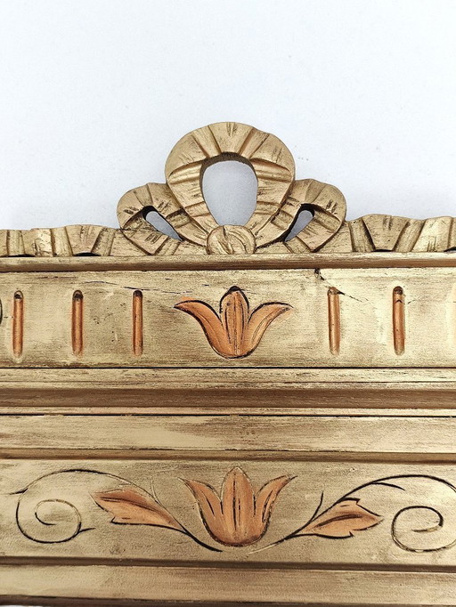 Gilded wooden mirror with carved pediment in the trumeau style