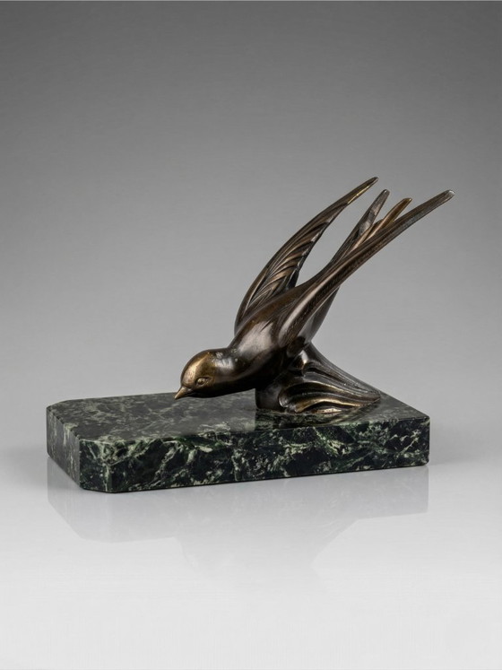 Image 1 of Een paar art-deco boekensteunen – zwaluwen van gepatineerd zink op groene marmeren voetstukken.