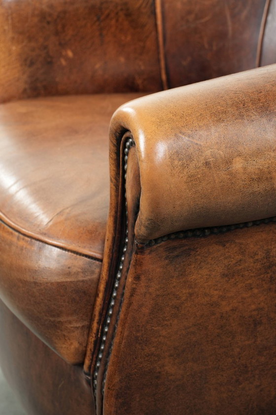 Image 1 of Karaktervolle en comfortabele clubfauteuil gemaakt van schapenleer met een vast zitkussen en uitmuntende kleuren