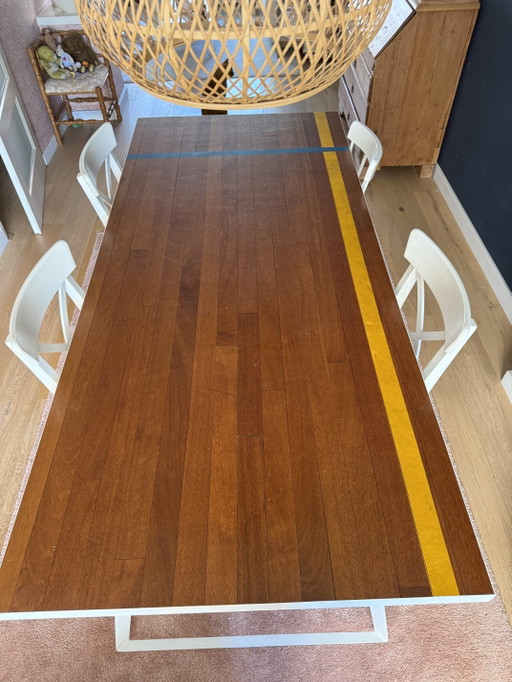 Unique dining table with a top made from vintage gymnasium flooring