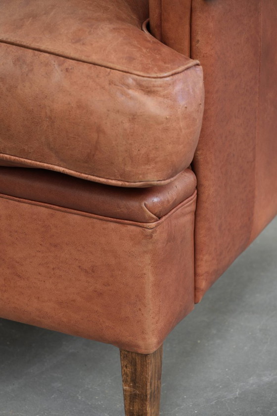 Image 1 of Poltrona a orecchioni color cognac chiaro, rivestita in pelle bovina, dal caratteristico look inglese.