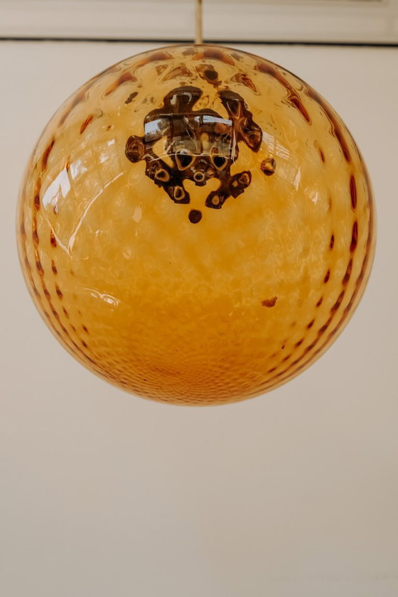 Brass Pendant Lamp with Round Orange Glass Shade and Swirl Structure (photo 4 of 8)
