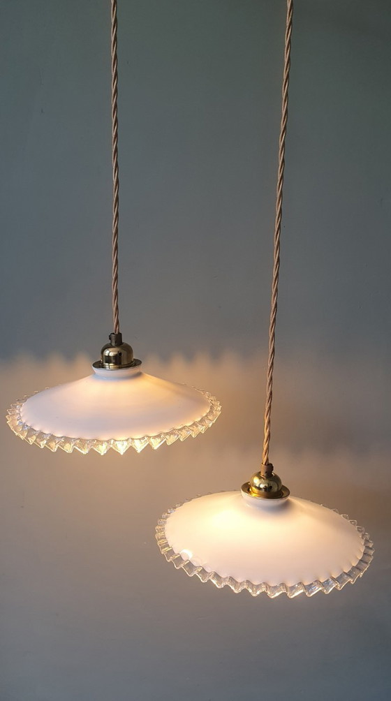 Image 1 of 2 vintage hanglampen van wit opaline glas met een transparante sierrand.