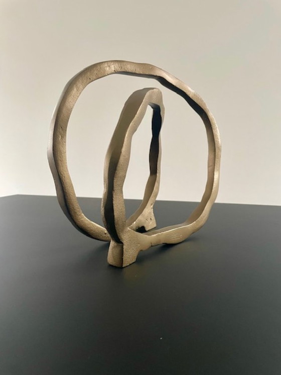 Image 1 of Escultura de diseño con forma de anillo abierto en oro mate.