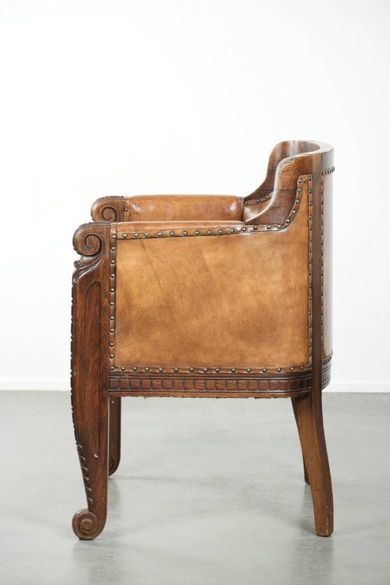 Image 1 of Antique armchair of sheepskin and wood with decorative nails and beautiful woodwork