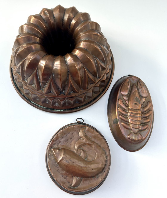 Image 1 of Collection de moules à pâtisserie anciens en cuivre – gâteau Bundt, poisson et homard – datant du début du XXe siècle.