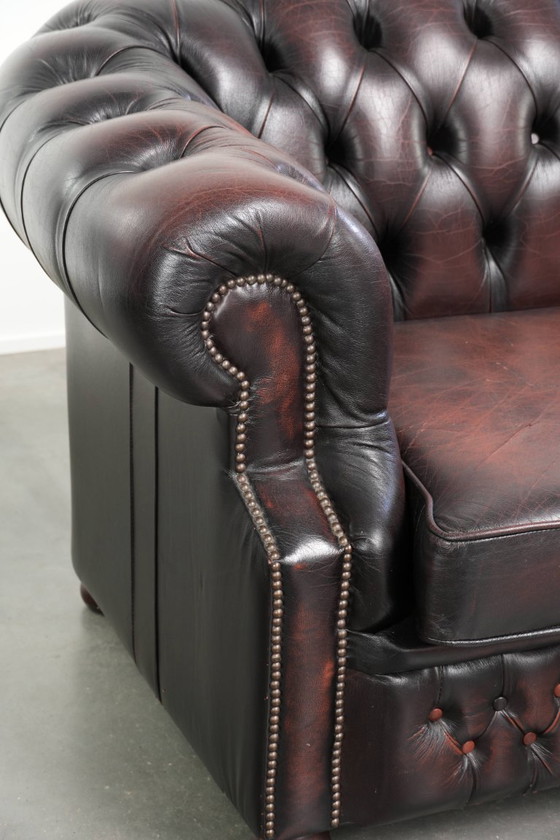 Image 1 of Canapé Chesterfield 2 places en cuir de vachette anglais ancien rouge/marron, au style magnifique et au charme intemporel.