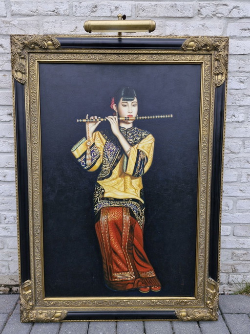 Chinesische Frau spielt Bambusflöte