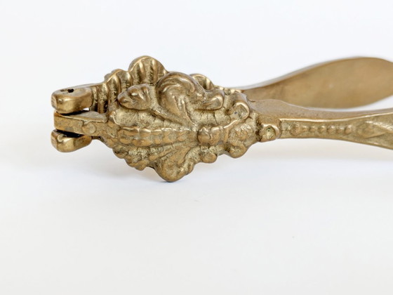 Image 1 of Vintage messing notenkraker met fleur-de-lys, sierlijke bloemenversiering voor een Hollywood Regency keuken.