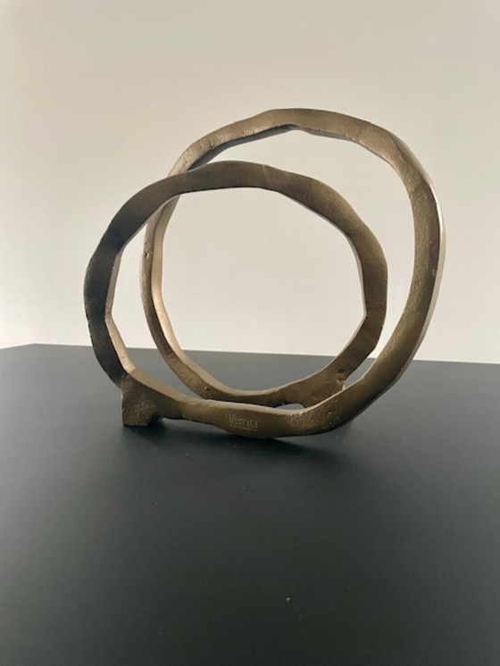 Image 1 of Escultura de diseño con forma de anillo abierto en oro mate.