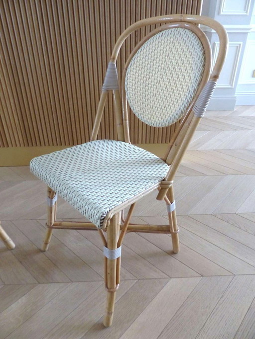 Een paar Parijse bistrostolen van Maison Louis Drucker in licht Manila-rotan.