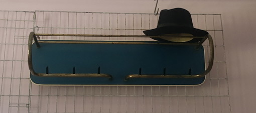 Perchero de pared original de los años 50, color azul petróleo, con estructura tubular dorada.