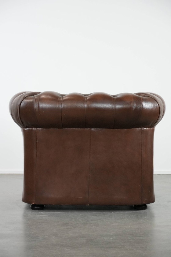 Image 1 of Impresionante sillón Chesterfield de piel de vaca marrón al estilo inglés, acabado con clavos decorativos.