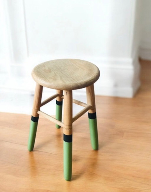 Massivholzhocker mit grünen und schwarzen Beinen