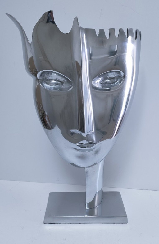 sculpture visage stylisé métal poli