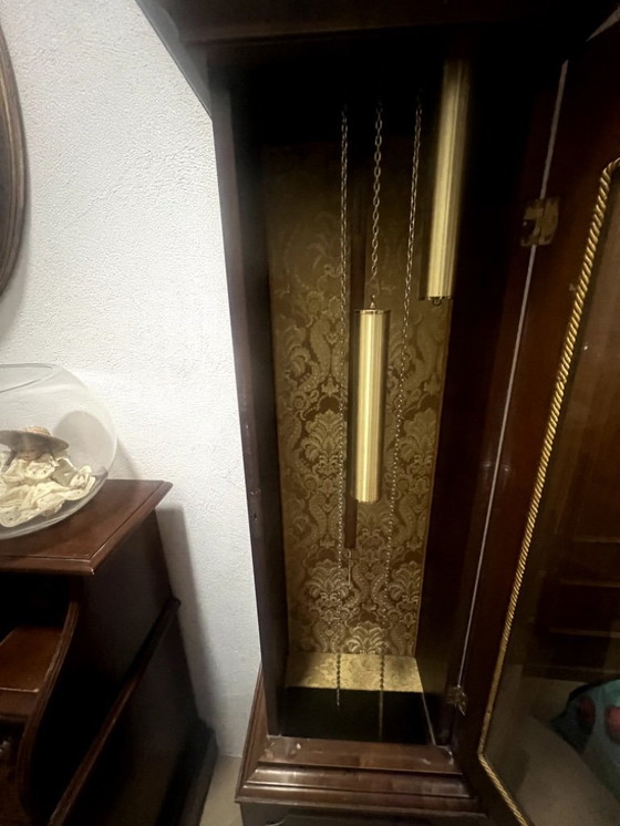 Image 1 of Eine hölzerne Pendeluhr mit einem Schweizer mechanischen Uhrwerk