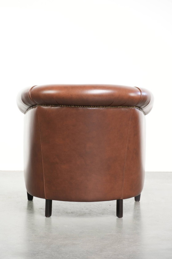 Image 1 of Bellissima e comoda poltrona club in stile inglese, rivestita in pelle di vacchetta color cognac.